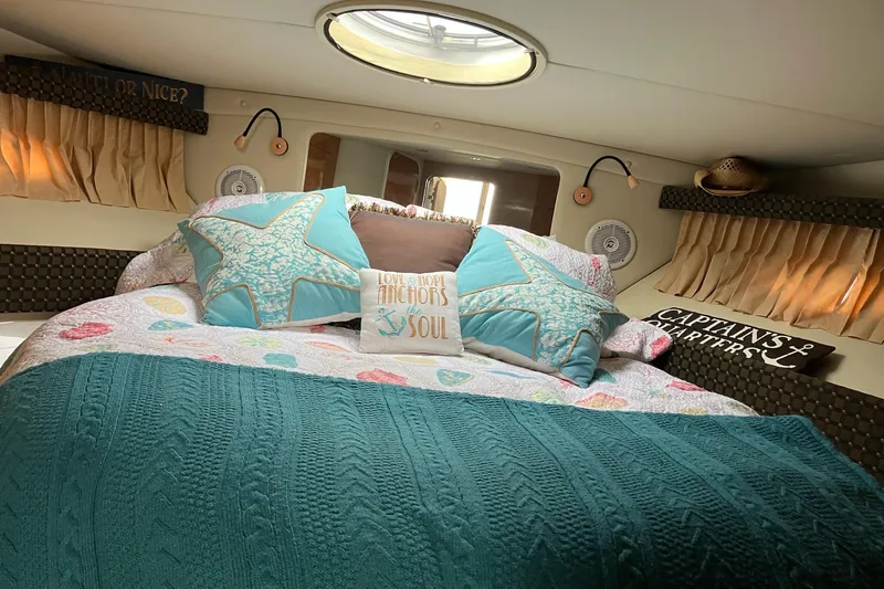 25 Knots Yacht Photos Pics Cozy cabin interior of 2001 Regal Commodore 3780 with nautical decor and bedding.