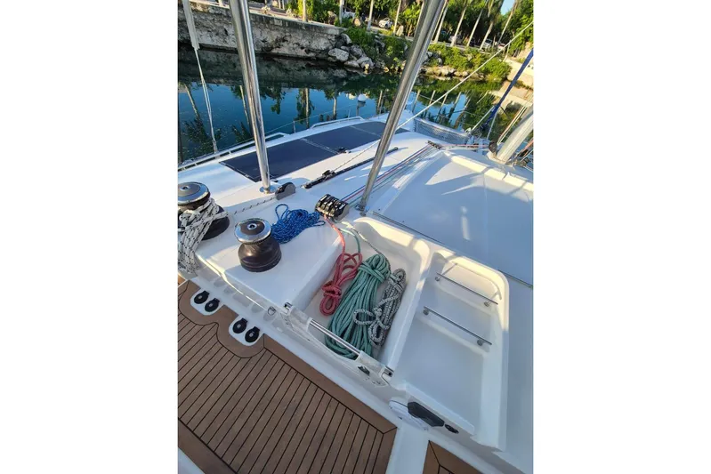 Chapter Two Yacht Photos Pics 2014 Lagoon 450 yacht deck with ropes and winches, docked by a calm waterway.
