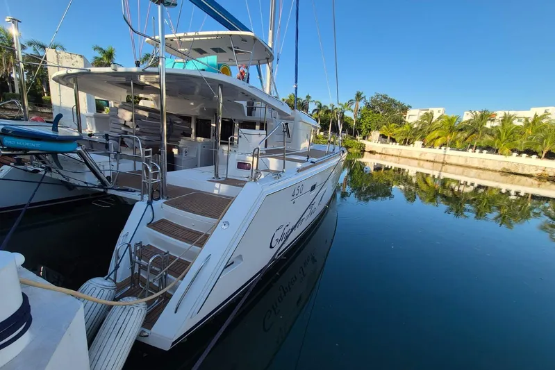 Chapter Two Yacht Photos Pics 2014 Lagoon 450 catamaran docked in a serene marina with clear blue skies.