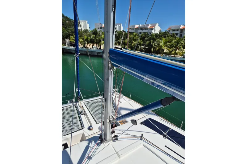 Chapter Two Yacht Photos Pics Lagoon 450 catamaran deck view, 2014 model, with blue sail and tropical backdrop.