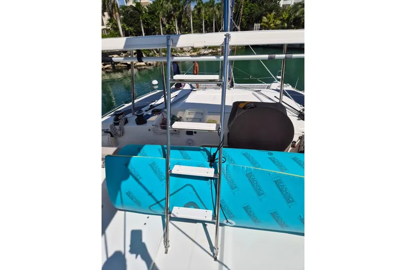 Chapter Two Yacht Photos Pics 2014 Lagoon 450 catamaran deck with ladder and seating, docked near lush greenery.