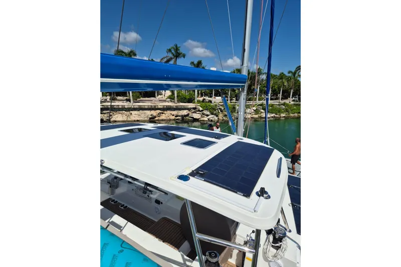 Chapter Two Yacht Photos Pics 2014 Lagoon 450 catamaran with solar panels, docked in a tropical marina.