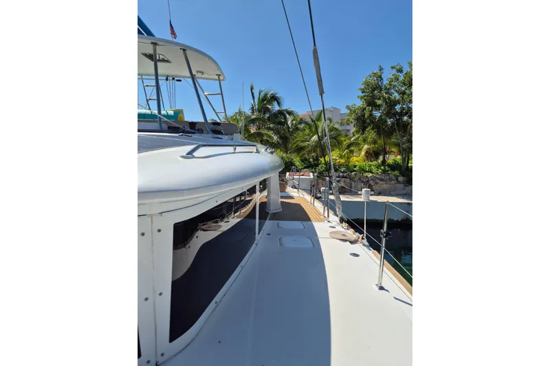 Chapter Two Yacht Photos Pics Lagoon 450 catamaran, 2014 model, docked with tropical trees in the background.