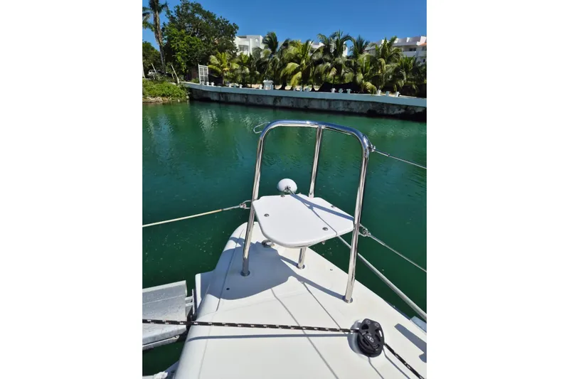 Chapter Two Yacht Photos Pics Lagoon 450 catamaran bow view, 2014 model, docked near lush greenery and calm waters.