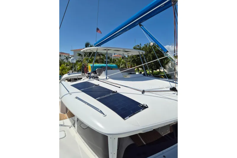 Chapter Two Yacht Photos Pics 2014 Lagoon 450 catamaran with solar panels and blue sail, docked under clear sky.