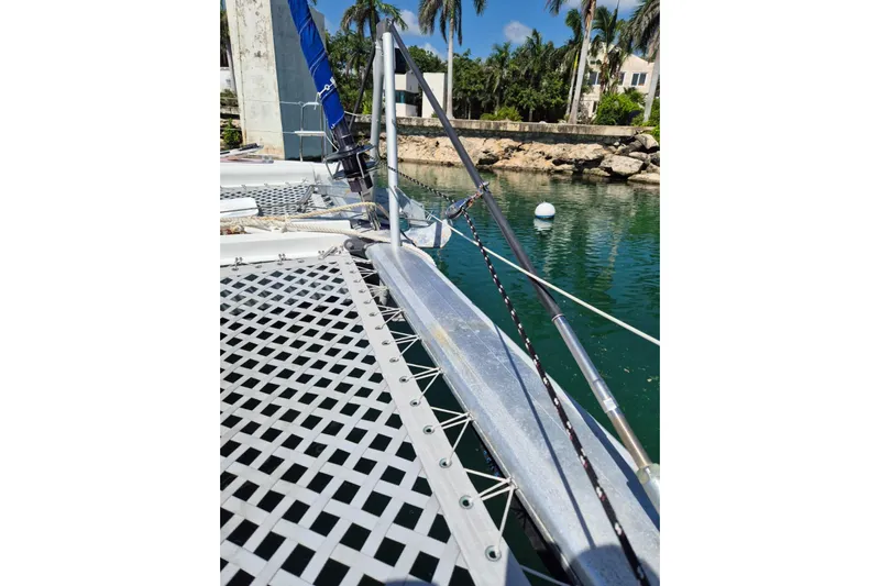Chapter Two Yacht Photos Pics 2014 Lagoon 450 catamaran deck with netting, docked near tropical palm trees.