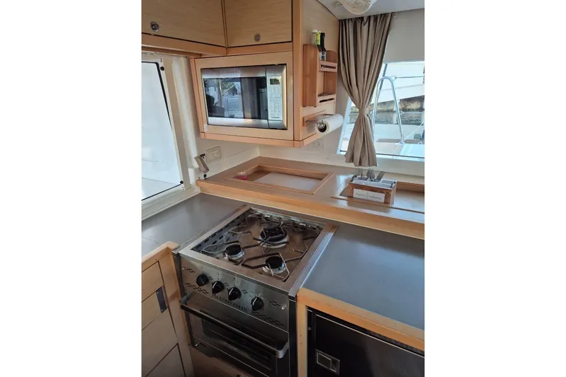 Chapter Two Yacht Photos Pics Modern kitchen interior of 2014 Lagoon 450 yacht with stove and microwave.