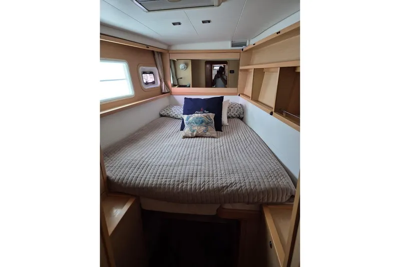Chapter Two Yacht Photos Pics Cozy bedroom interior of 2014 Lagoon 450 catamaran with comfortable bedding and wooden shelves.