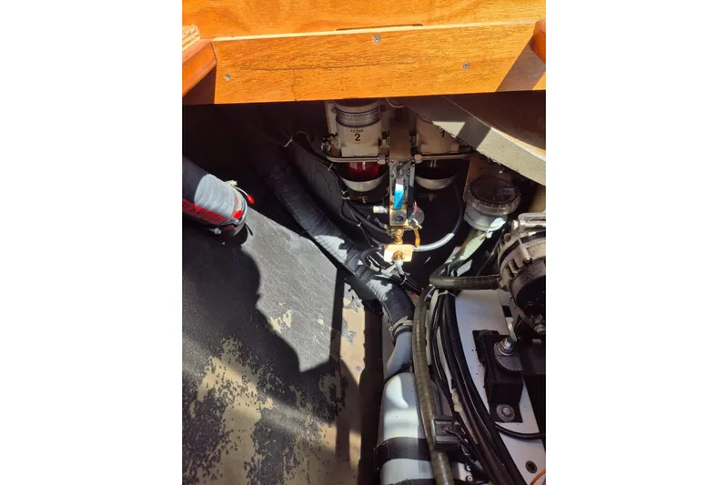 Chapter Two Yacht Photos Pics Engine compartment of a 2014 Lagoon 450 catamaran, showcasing mechanical components and hoses.