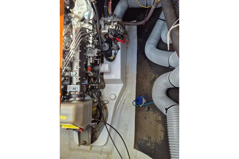 Chapter Two Yacht Photos Pics Engine compartment of a 2014 Lagoon 450 catamaran, showcasing mechanical components and hoses.