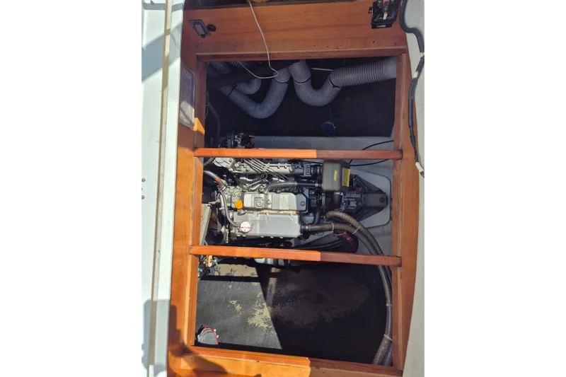 Chapter Two Yacht Photos Pics Engine compartment of a 2014 Lagoon 450 catamaran, showcasing mechanical components and wooden framing.