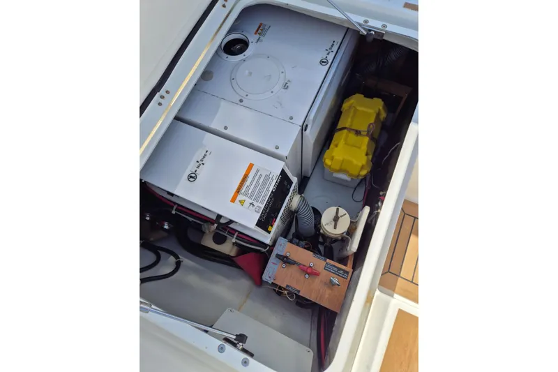 Chapter Two Yacht Photos Pics Engine compartment of a 2014 Lagoon 450 catamaran, showcasing mechanical components and battery.