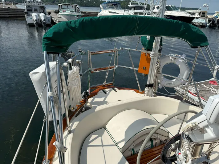 Dalliance Yacht Photos Pics 1993 Pacific Seacraft Crealock 34 sailboat cockpit with green canopy, docked at marina.
