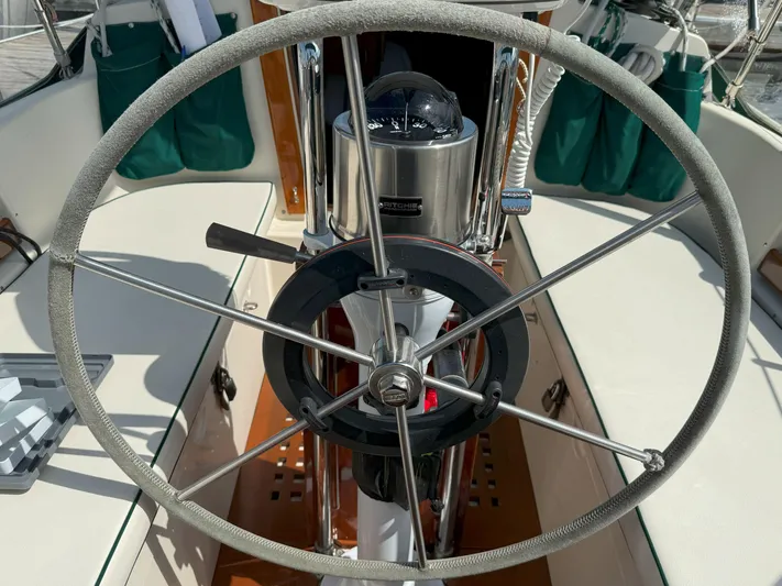 Dalliance Yacht Photos Pics Steering wheel of a 1993 Pacific Seacraft Crealock 34 sailboat, featuring a compass.