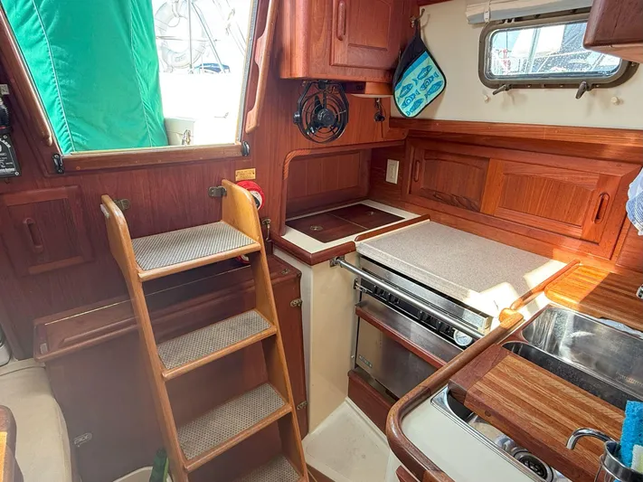 Dalliance Yacht Photos Pics Cozy galley of 1993 Pacific Seacraft Crealock 34 sailboat with wooden cabinetry and compact design.