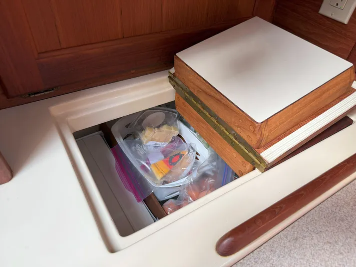 Dalliance Yacht Photos Pics Hidden storage compartment on a 1993 Pacific Seacraft Crealock 34 sailboat, containing various items.