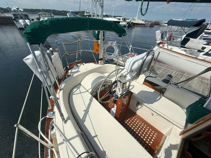 Dalliance Yacht Photos Pics 1993 Pacific Seacraft Crealock 34 sailboat cockpit with green canopy, docked at marina.