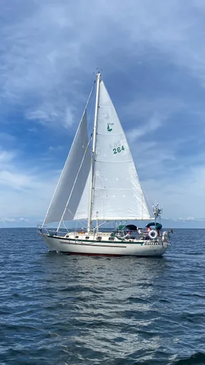 Dalliance Yacht Photos Pics Sailboat Pacific Seacraft Crealock 34, 1993 model, sailing on open sea under clear blue sky.