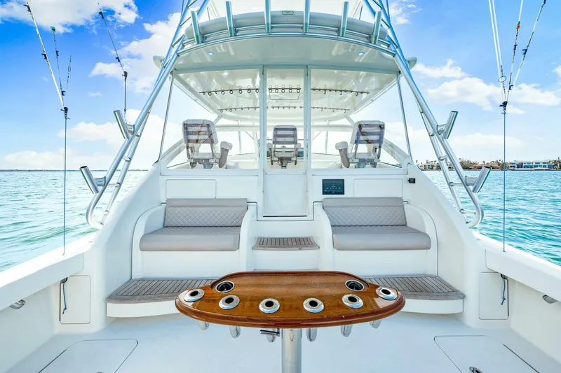 Bad Habit Yacht Photos Pics 2012 Viking 42 Open yacht interior with seating and fishing rod holders on a sunny day.