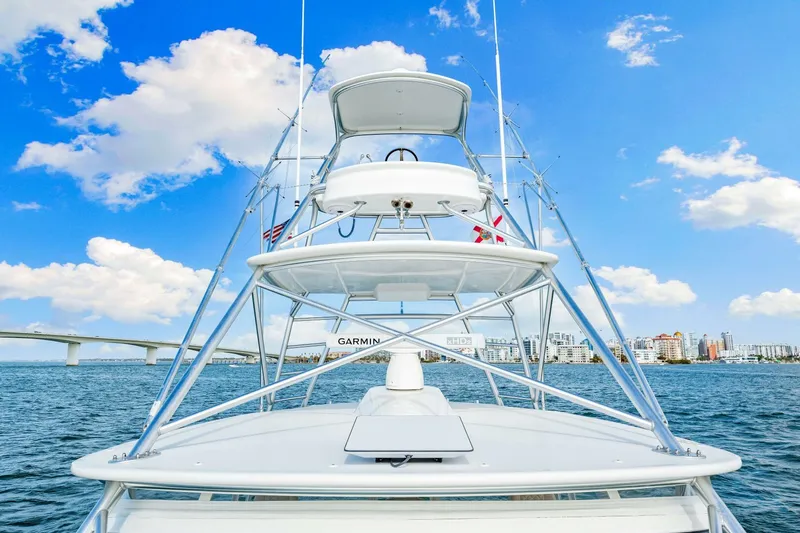 Bad Habit Yacht Photos Pics 2012 Viking 42 Open yacht on water with city skyline and bridge in background.