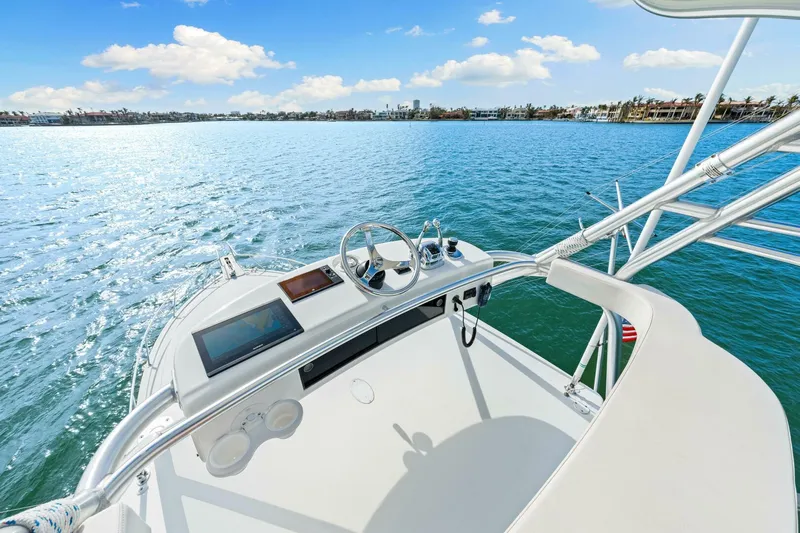 Bad Habit Yacht Photos Pics Helm of 2012 Viking 42 Open yacht on calm water under blue sky.