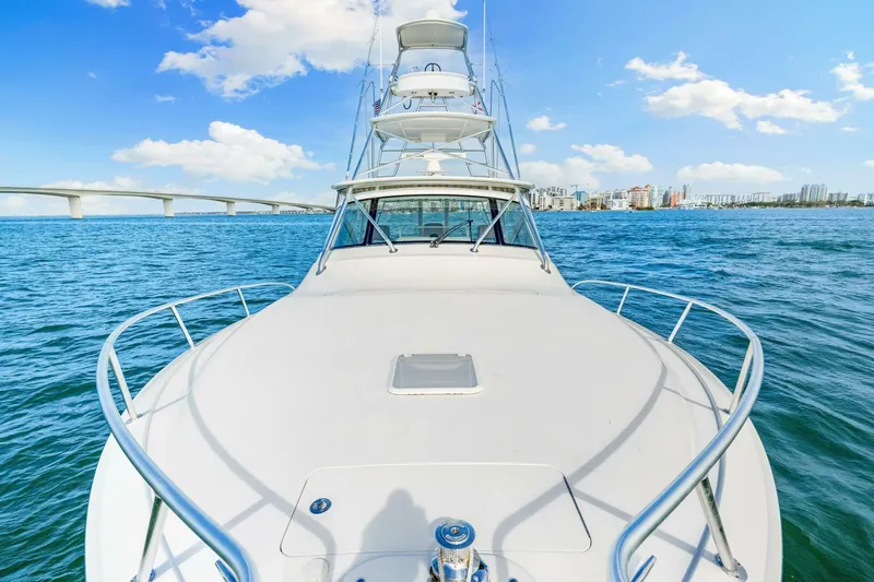 Bad Habit Yacht Photos Pics 2012 Viking 42 Open yacht cruising on blue ocean with city skyline and bridge in background.