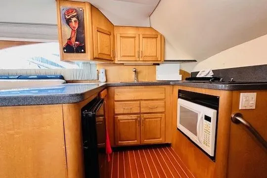 Lolita Yacht Photos Pics Kitchen area of 2001 Luhrs 40 Convertible boat with wood cabinets and modern appliances.