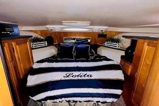 Lolita Yacht Photos Pics Luxurious cabin interior of 2001 Luhrs 40 Convertible yacht with striped bedding.