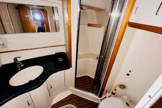 Lolita Yacht Photos Pics Luxurious bathroom in 2001 Luhrs 40 Convertible yacht with modern fixtures and wood accents.