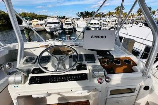 Lolita Yacht Photos Pics 2001 Luhrs 40 Convertible yacht helm with Simrad navigation, docked among other boats.