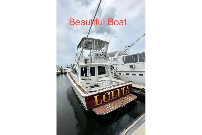 Lolita Yacht Photos Pics 2001 Luhrs 40 Convertible boat docked, named "Lolita," with fishing rods and upper deck.