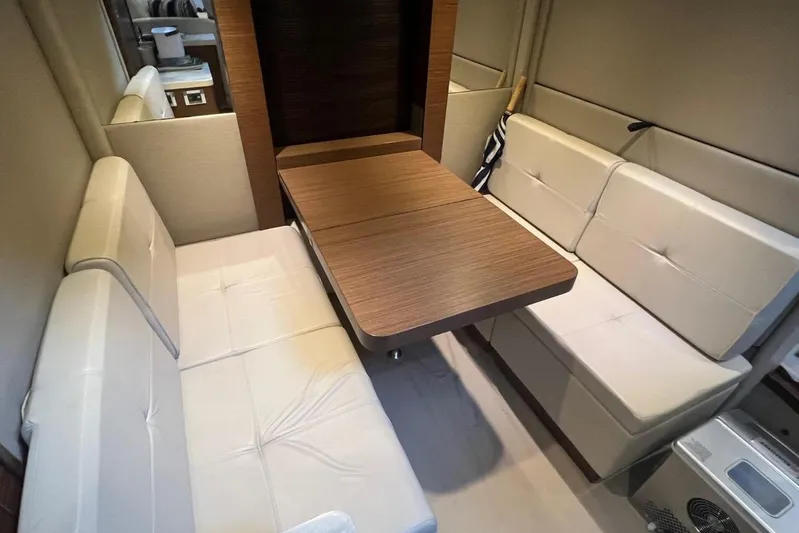  Yacht Photos Pics Interior of 2014 Sea Ray 410 Sundancer with beige seating and wooden table.