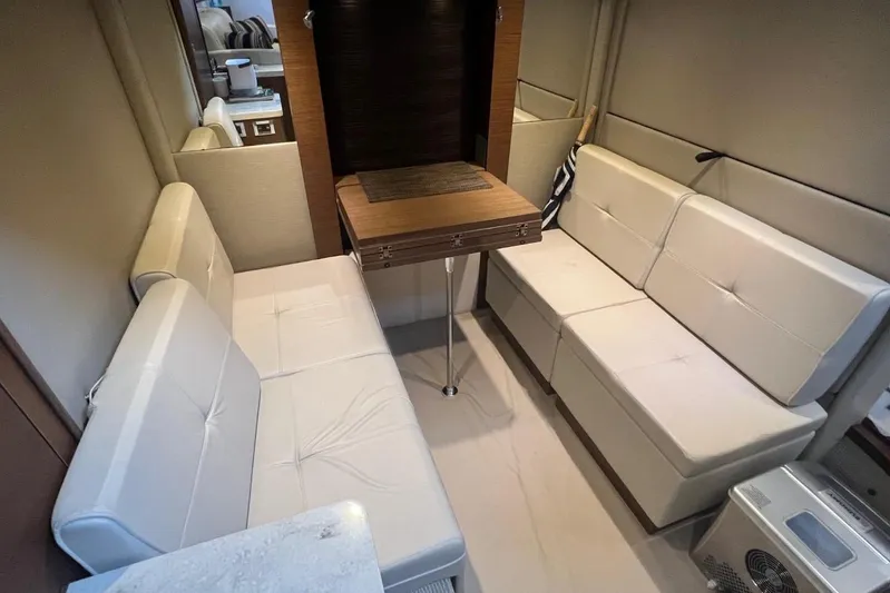  Yacht Photos Pics Interior of 2014 Sea Ray 410 Sundancer with beige seating and wooden table.