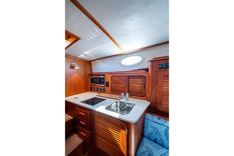 Odelay Yacht Photos Pics 2016 Hinckley Picnic Boat MKIII interior with wooden cabinetry, sink, and microwave.