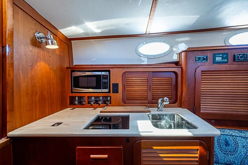 Odelay Yacht Photos Pics 2016 Hinckley Picnic Boat MKIII interior kitchen with wood cabinetry and modern appliances.