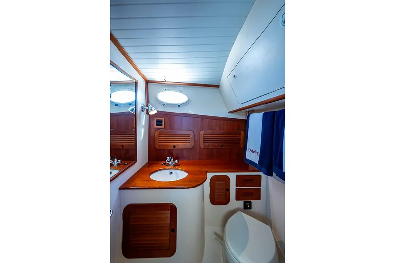 Odelay Yacht Photos Pics 2016 Hinckley Picnic Boat MKIII bathroom with wooden cabinetry and modern fixtures.
