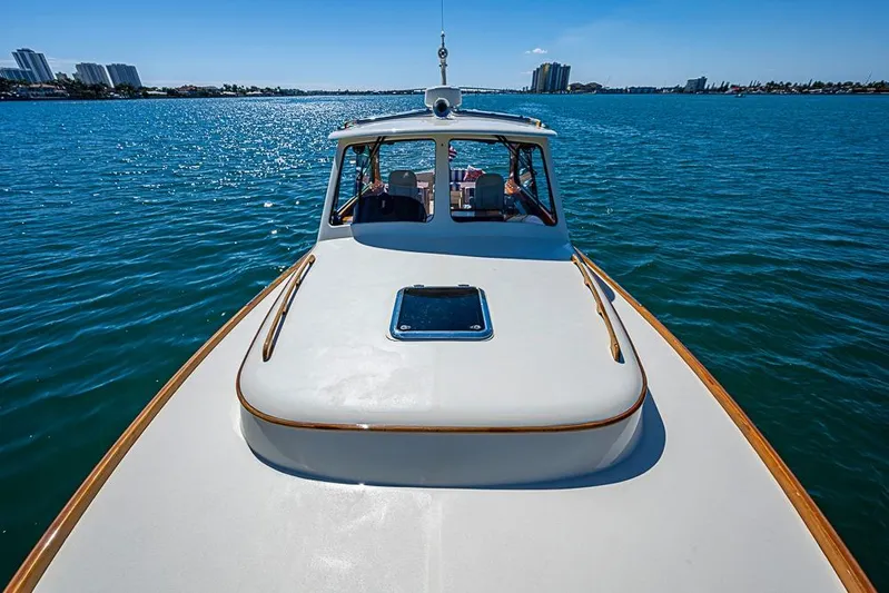 Odelay Yacht Photos Pics 2016 Hinckley Picnic Boat MKIII cruising on a sunny day, with city skyline in background.