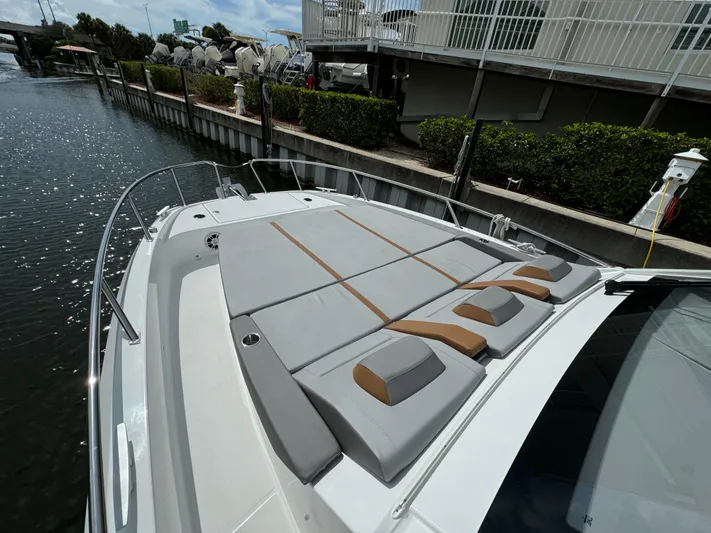  Yacht Photos Pics 2024 Beneteau Gran Turismo 32 yacht with spacious sunbathing area docked by the water.
