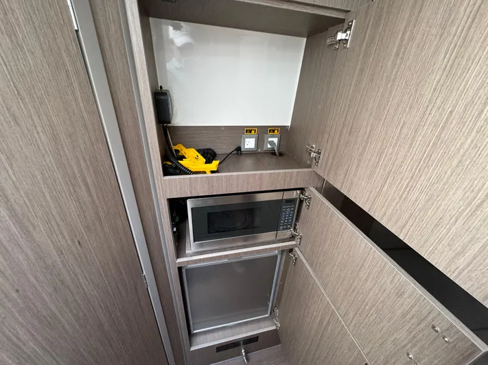  Yacht Photos Pics 2024 Beneteau Gran Turismo 32 interior kitchen with microwave and storage cabinets.