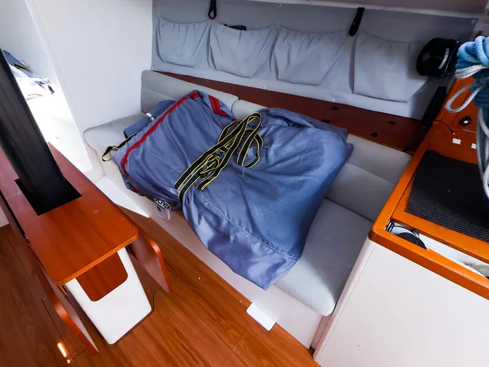  Yacht Photos Pics Interior of 2020 J Boats J/99 sailboat with sail bag on cushioned bench.