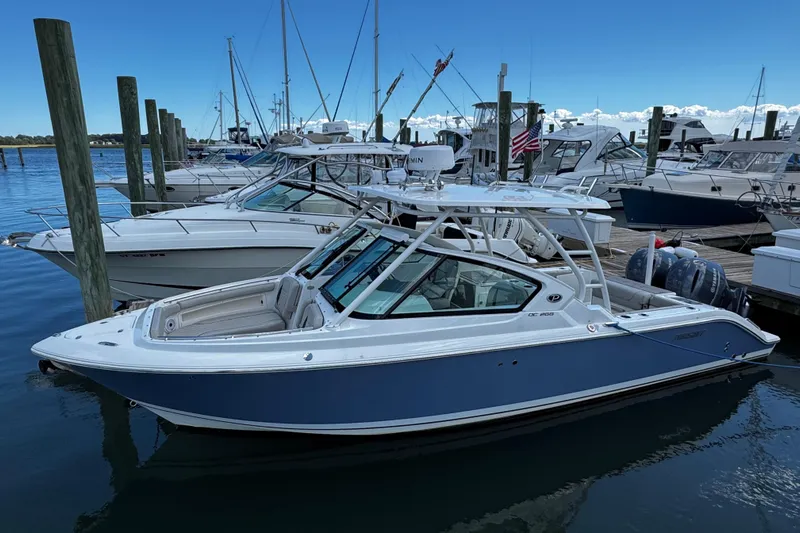 Luna Sea Yacht Photos Pics 2023 Pursuit DC 266 Dual Console boat docked at a marina, surrounded by other vessels.