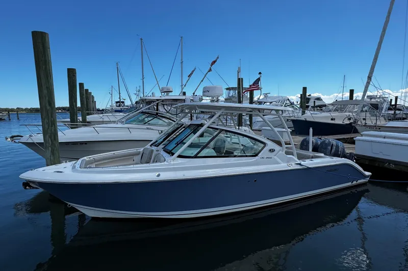 Luna Sea Yacht Photos Pics 2023 Pursuit DC 266 Dual Console boat docked in a marina, clear blue sky.