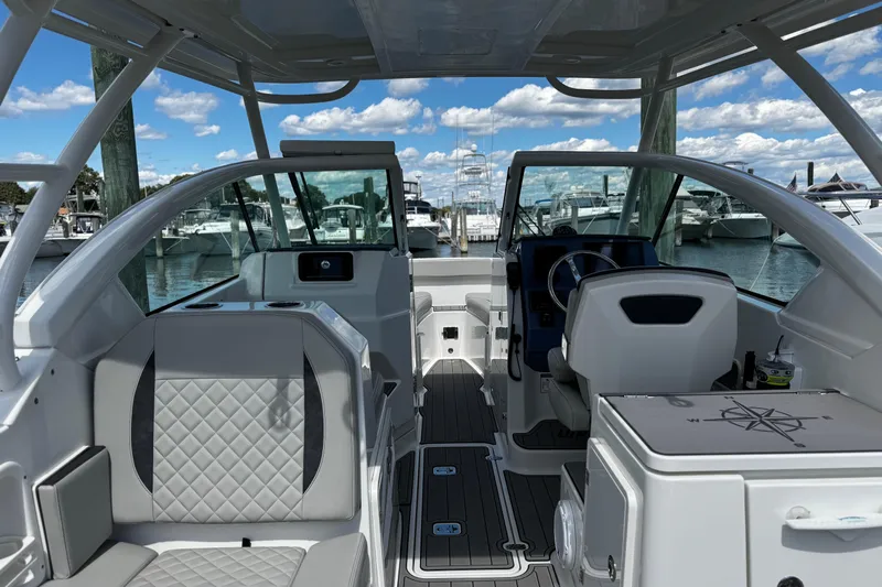 Luna Sea Yacht Photos Pics 2023 Pursuit DC 266 Dual Console boat interior with seating and helm, docked at marina.