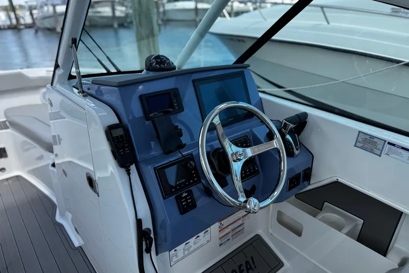 Luna Sea Yacht Photos Pics 2023 Pursuit DC 266 Dual Console boat dashboard with steering wheel and navigation controls.