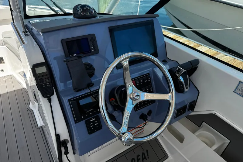 Luna Sea Yacht Photos Pics 2023 Pursuit DC 266 Dual Console boat dashboard with steering wheel and navigation controls.