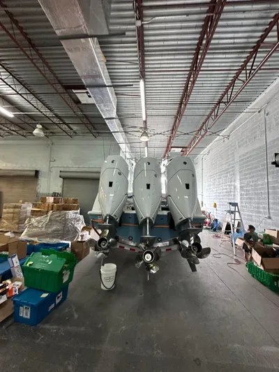  Yacht Photos Pics 2025 Invincible 36 Open boat with triple engines in a warehouse setting.