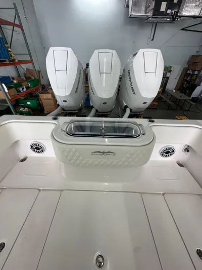  Yacht Photos Pics 2025 Invincible 36 Open boat with triple Mercury engines in a warehouse setting.