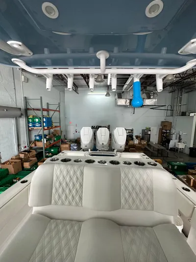  Yacht Photos Pics 2025 Invincible 36 Open boat interior with seating and rod holders in a warehouse setting.