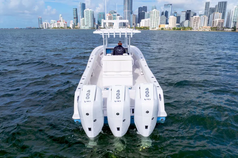  Yacht Photos Pics 2025 Invincible 36 Open boat with triple engines cruising near city skyline.