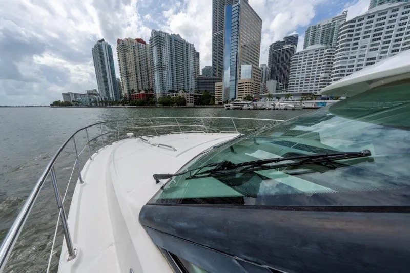  Yacht Photos Pics Sea Ray 43 Sundancer 2009 cruising near city skyline on a cloudy day.